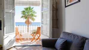 An open balcony with a view of the sea, a palm tree, and a dining area with chairs and a table. - Charming apartment, first line of the Center Beach, Villajoyosa (Villajoyosa)