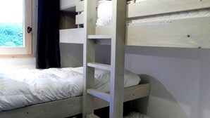 A bunk bed room with a window, a wooden ladder, and a label on the wall. - 3-Room Apartment on the Slopes, Perfect for Families (Méribel)