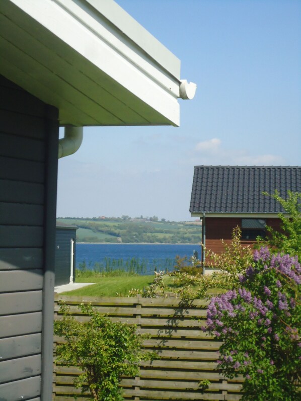 A house with a view of a lake and hills in the background.