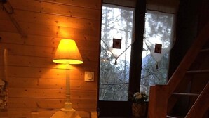 Ein gemütliches Zimmer mit Holzvertäfelung, einem Tisch gedeckt mit Teekanne, Tassen und einer Kuchen mit einer Krone als Verzierung.