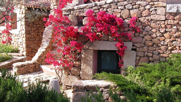 Un edificio de piedra con una ventana y una escalera de piedra.