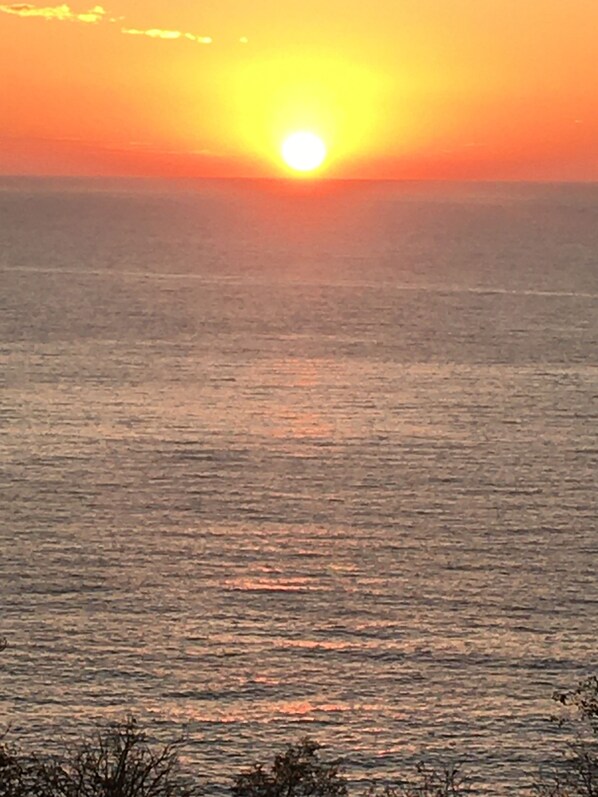 A sunset over a calm sea with a clear horizon.