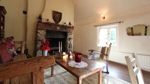 Ein gemütliches Wohnzimmer mit Kamin, Holzmöbeln und Blick ins Freie.