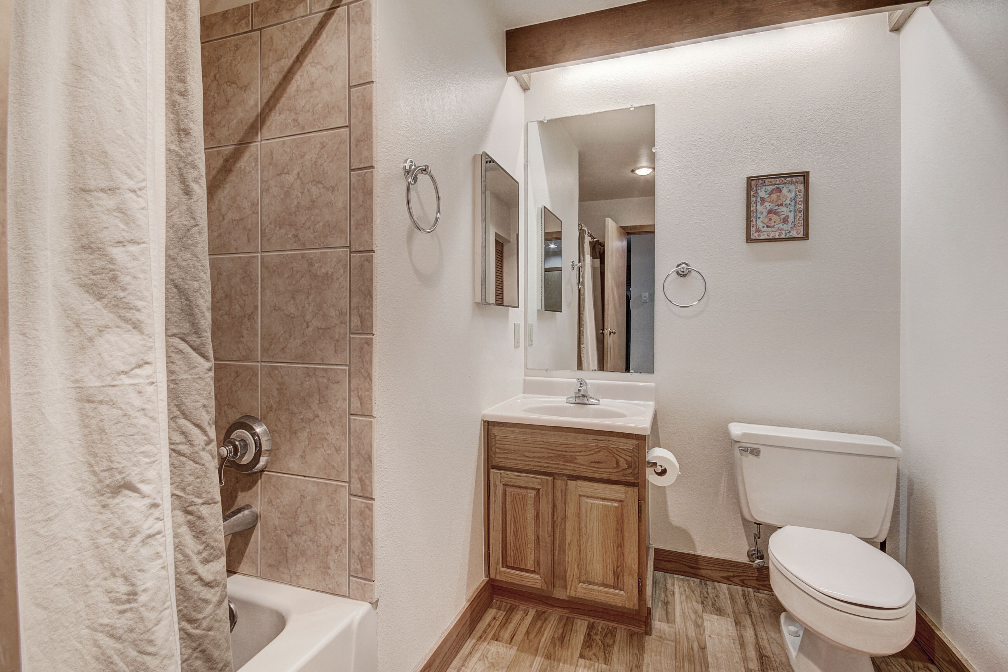 A bathroom with a bathtub, a toilet, a sink, and a shower area.