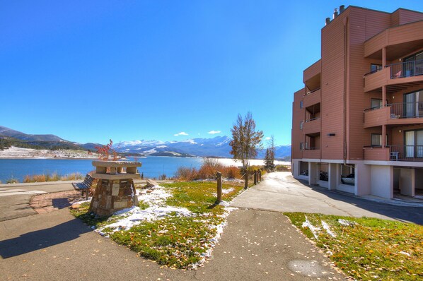 Un immeuble dot é de nombreux balcons donnant sur un lac et des montagnes.