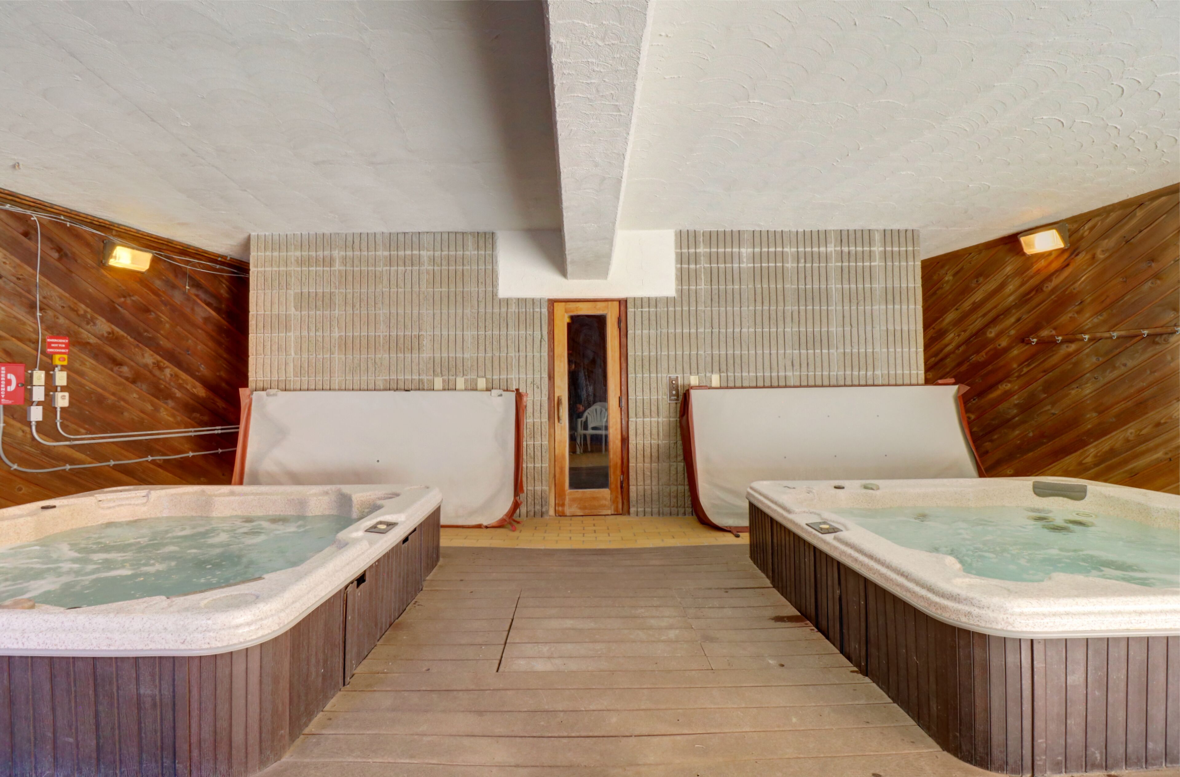 Un área de spa con dos jacuzzis y suelo de madera.