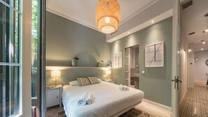 Camera da letto con un letto grande, lampade sui comodini, una mensola decorativa a parete e un tappeto a motivi.