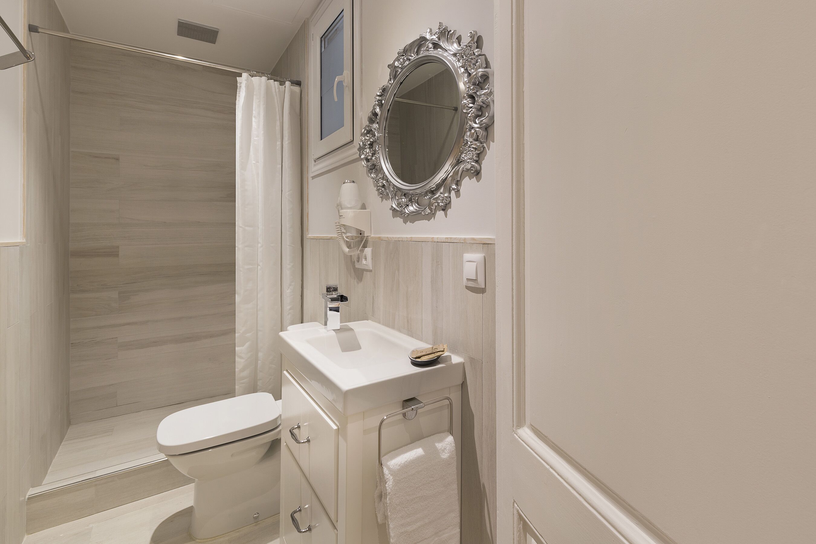 Une salle de bain moderne équipée d’une douche, de toilettes, d’un lavabo et d’un meuble-lavabo.