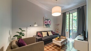 Un soggiorno moderno con divano, poltrona, tavolino e un quadro appeso al muro.
