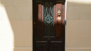 A dark wooden door with a brass knocker and a metal gate, set in a beige wall with a number '23' sign above. - Charming town house Avignon intra muros (Avignon)