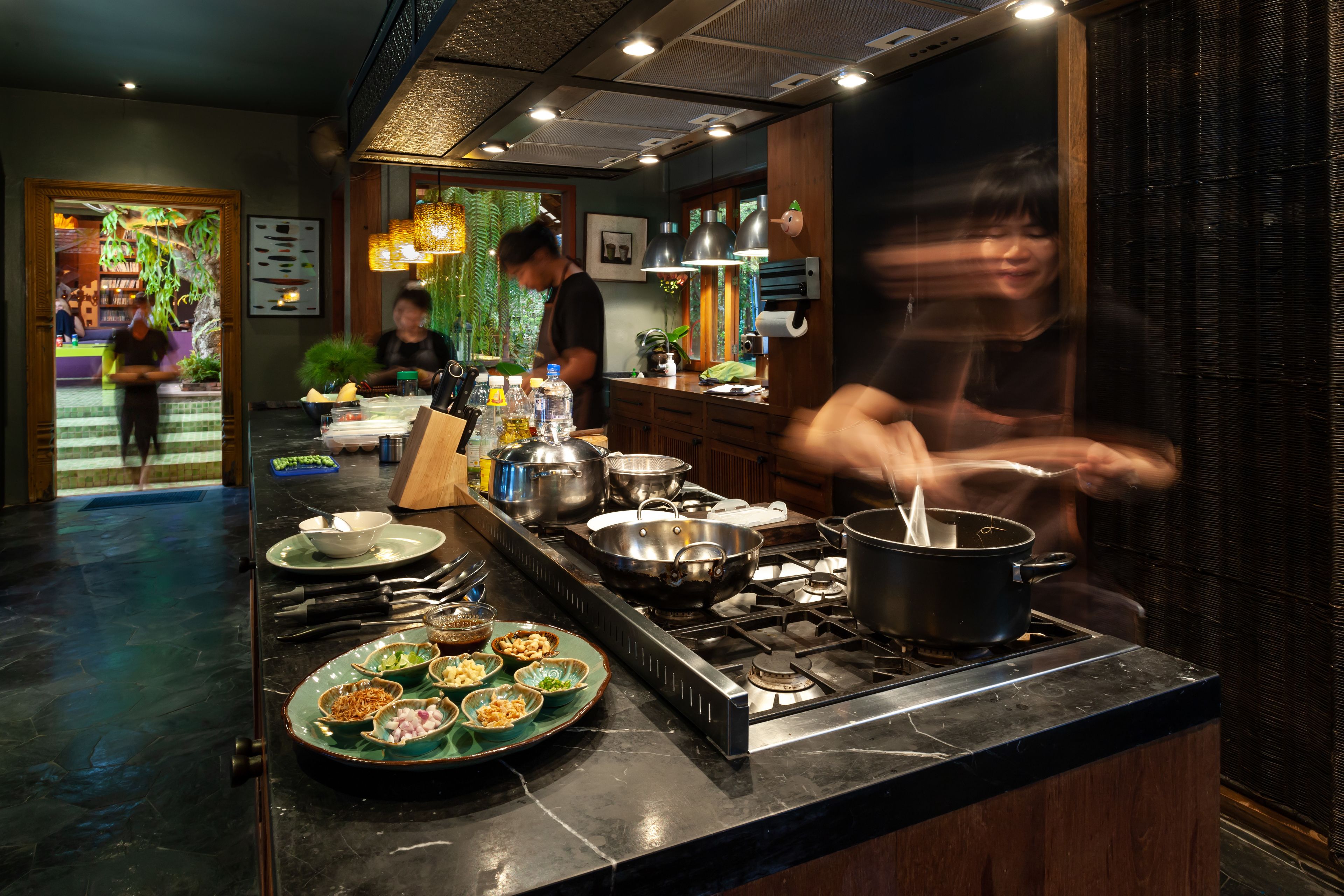 Una cocina con estufa a gas, ollas y tazones de comida sobre la encimera.