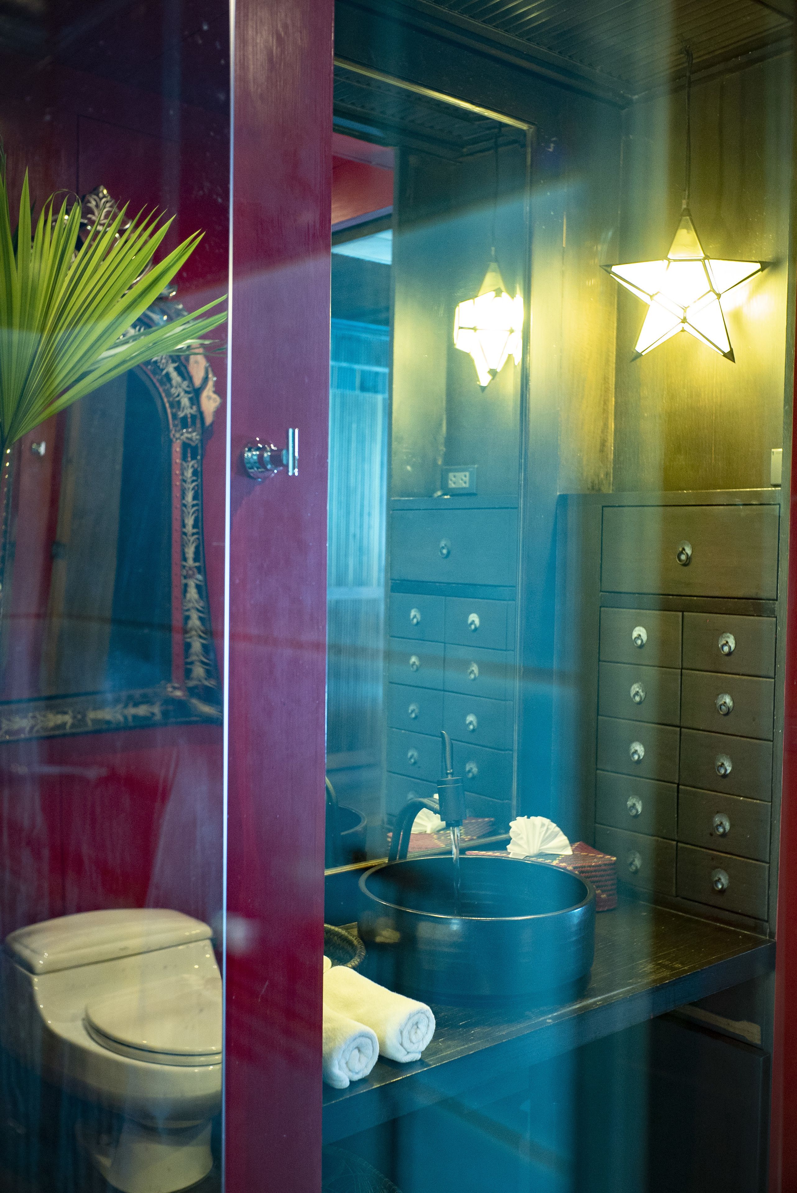 A bathroom with a mirror, a sink, a star-shaped light fixture, and a towel rack.