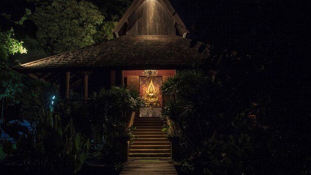 A wooden structure with a staircase leading to a room with a Buddha statue. - Chandra Residence (Hang Dong)