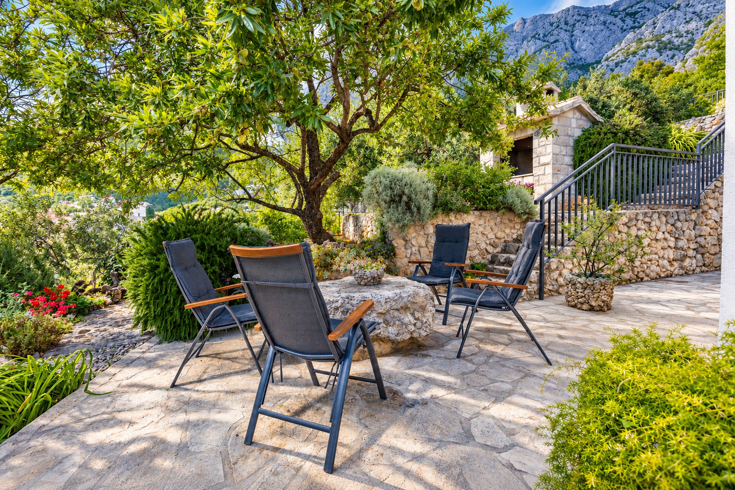 An outdoor seating area with stone flooring and metal chairs.