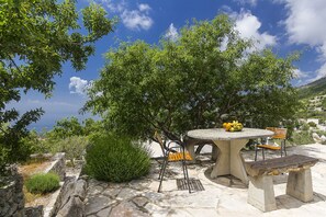 An outdoor patio with a round table, two chairs, and a bench. - Detached house with sea views, on 2. 000qm plot, 2 Schlafzi. (Makarska)