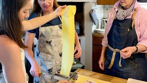 Una cocina con armarios de madera, encimera blanca y un rallador.