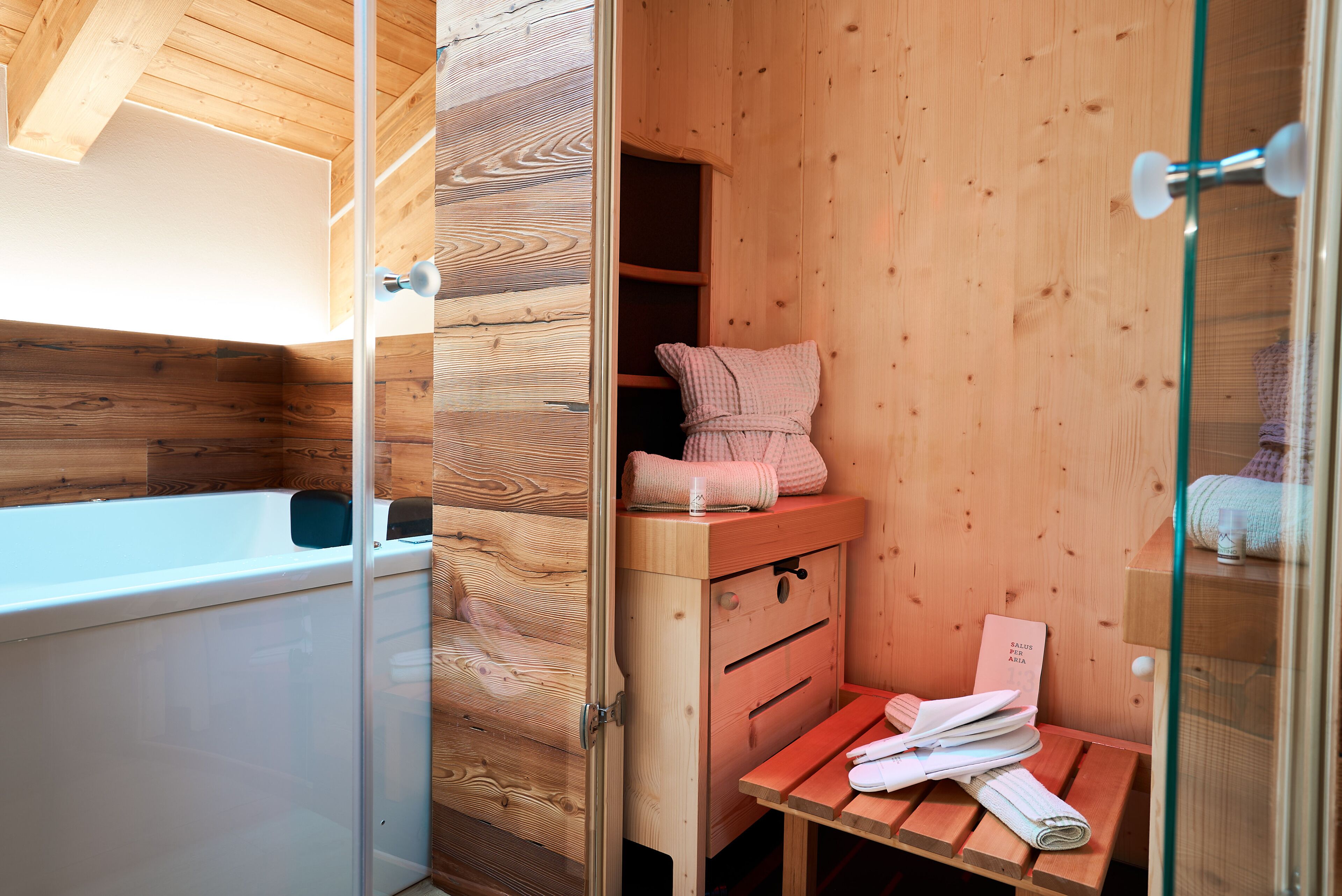 A wooden cabin-style bathroom with a bathtub, wooden shelves, and a bench.
