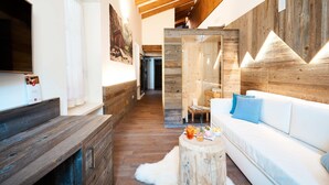 A modern living room with a wooden ceiling, a white sofa, and a wooden coffee table. - La Filanda Relax & Gourmet (Denno)