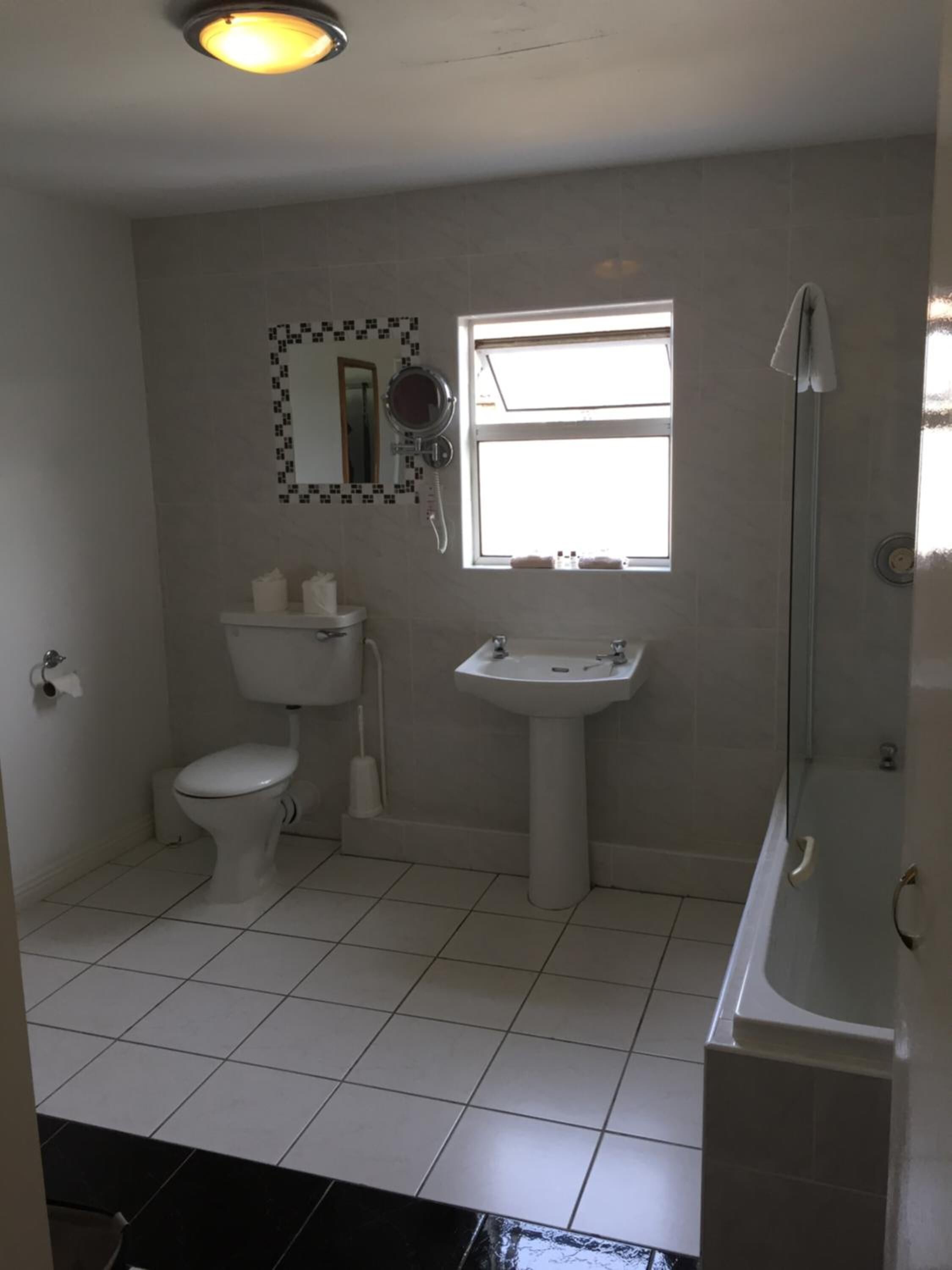Un baño con inodoro, lavamanos y ducha.
