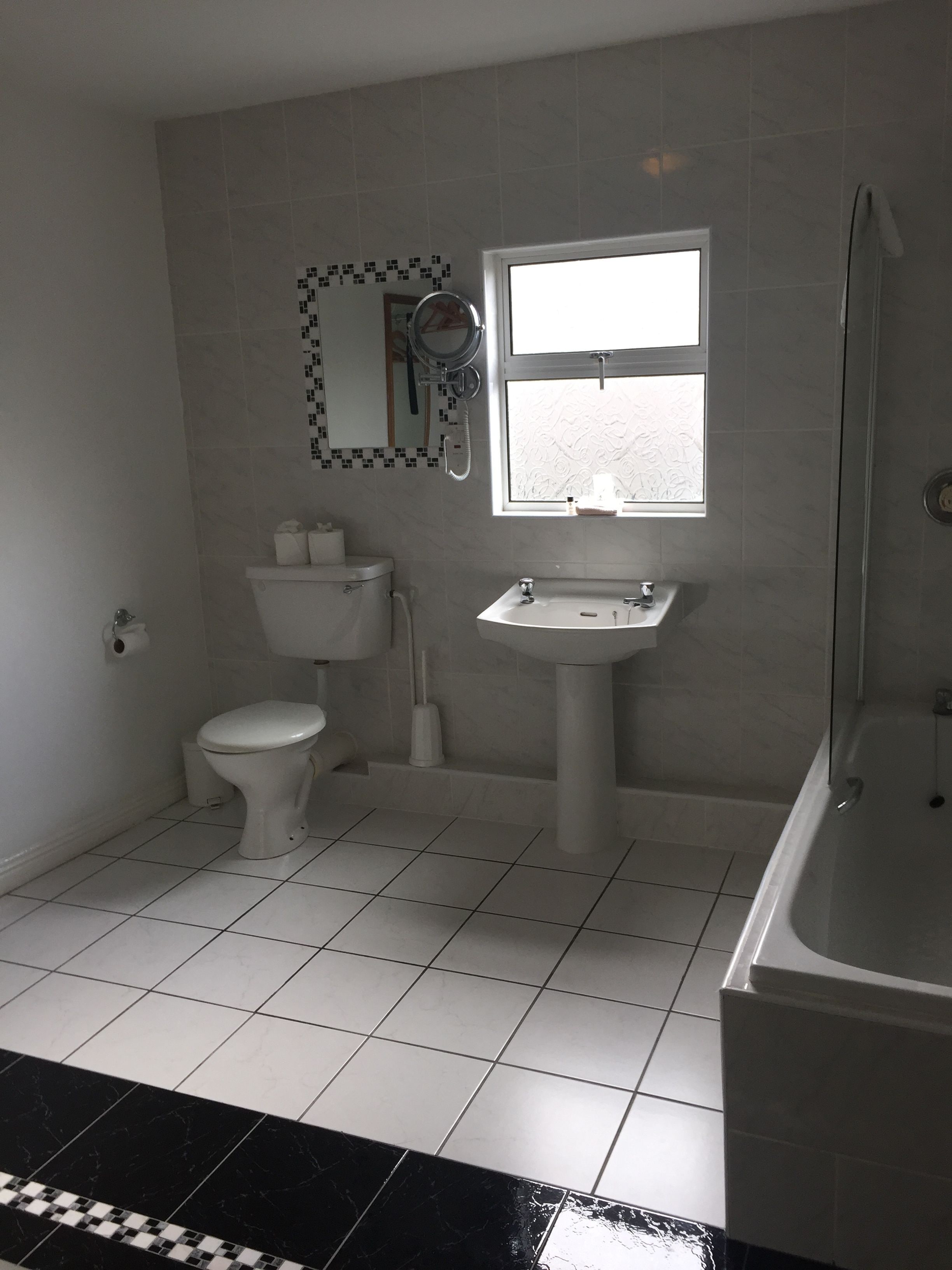 A bathroom with a toilet, sink, and bathtub.
