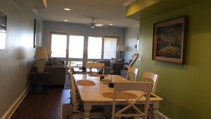 A dining area with a table and chairs, a ceiling fan, and a view through a glass door to an outdoor patio. - OCEANFRONT Midisle Prvt Pool 3New Baths,Kitchen,Floors, AC,Total Renovation!     (Fripp Island)