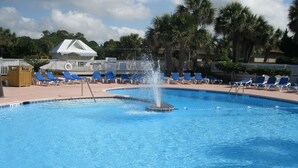 A swimming pool with a fountain, surrounded by lounge chairs and palm trees. - OCEANFRONT Midisle Prvt Pool 3New Baths,Kitchen,Floors, AC,Total Renovation!     (Fripp Island)