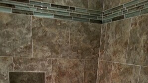A bathroom with a bathtub, a built-in shelf, and a showerhead.