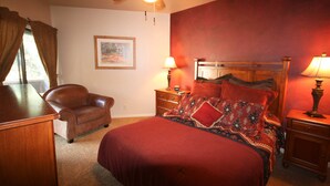 A bedroom with a bed, a chair, a nightstand, a lamp, a ceiling fan, and a window with curtains. - Right in the Heart of Park City (Park City)