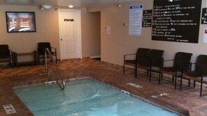 An indoor swimming pool with a tiled floor, a pool ladder, and a caution sign on the wall. - Right in the Heart of Park City (Park City)