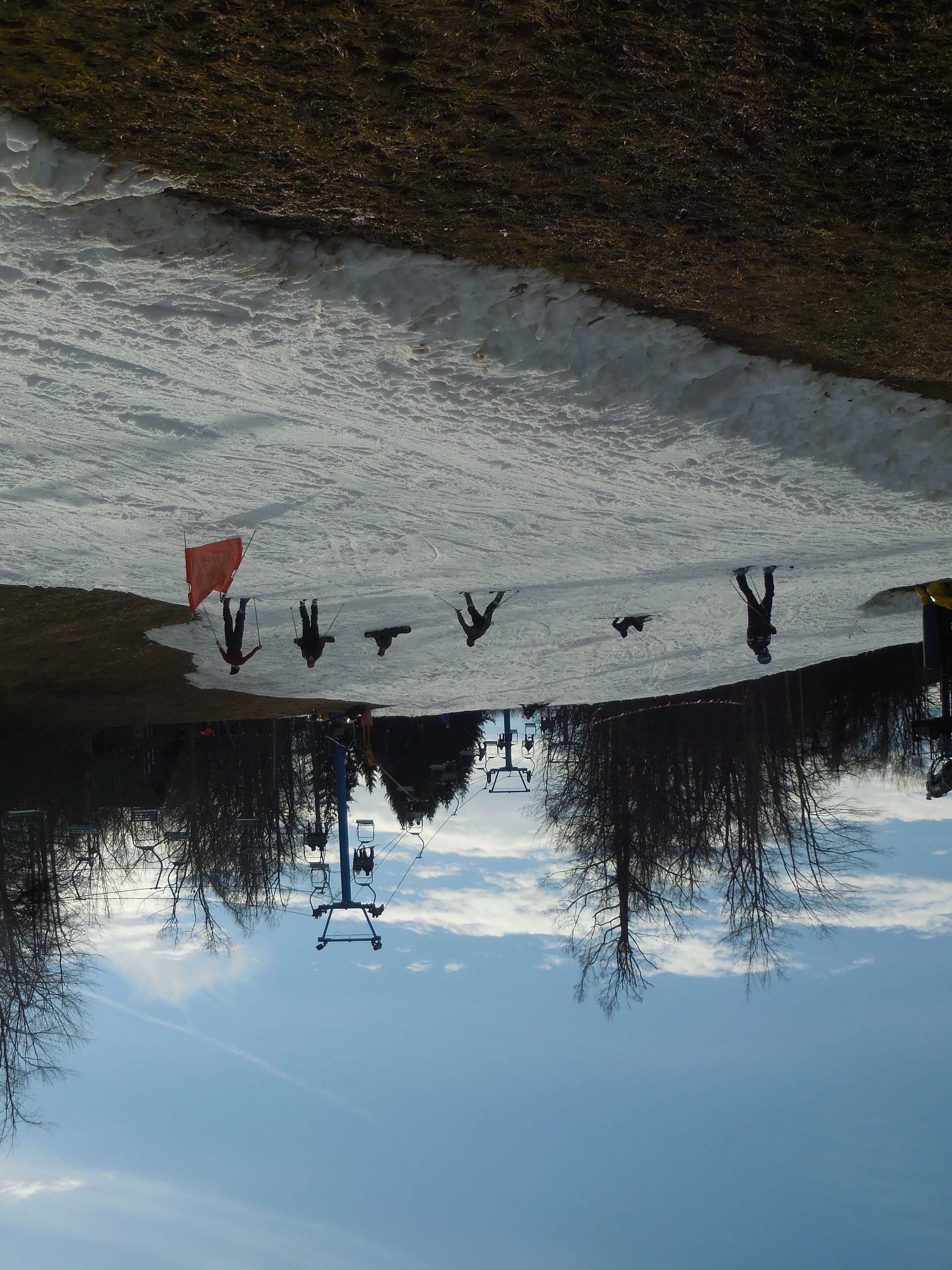 A snowy landscape with a ski lift and skiers.