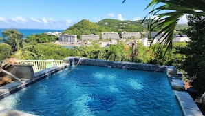 Piscina com vista para a área de um resort, incluindo edifícios e vegetação.