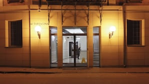 Un edificio con un letrero que dice "ul. TARTACZNA 2" y una entrada con puerta de vidrio.