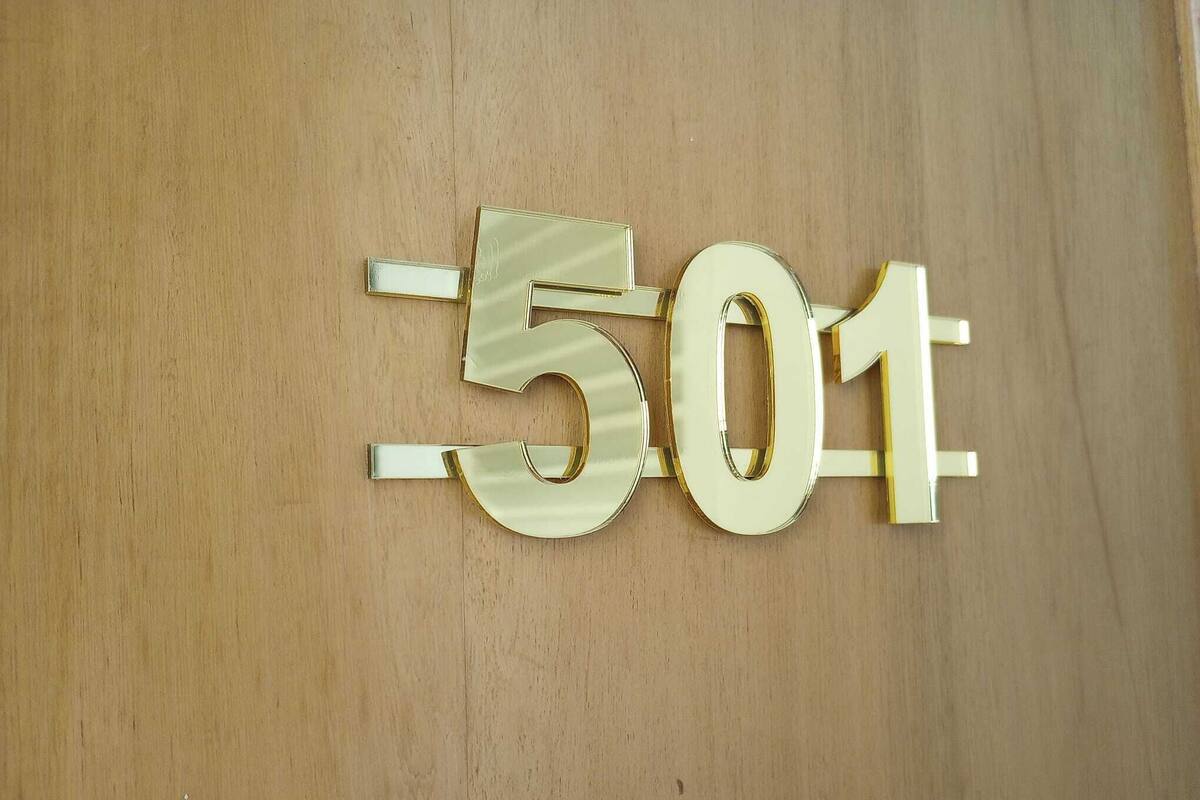 Une surface en bois portant un numéro doré indiquant l’adresse 501.
