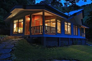 A modern house with a covered porch, large windows, and a stone pathway leading to the entrance. - Senda Monteverde Hotel Member of the Cayuga Collection (Monteverde)