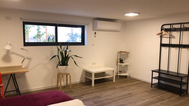 A room with a bed, a desk, a small table, a plant, a window, and a bunk bed. - Hassan guest house (Nazareth)