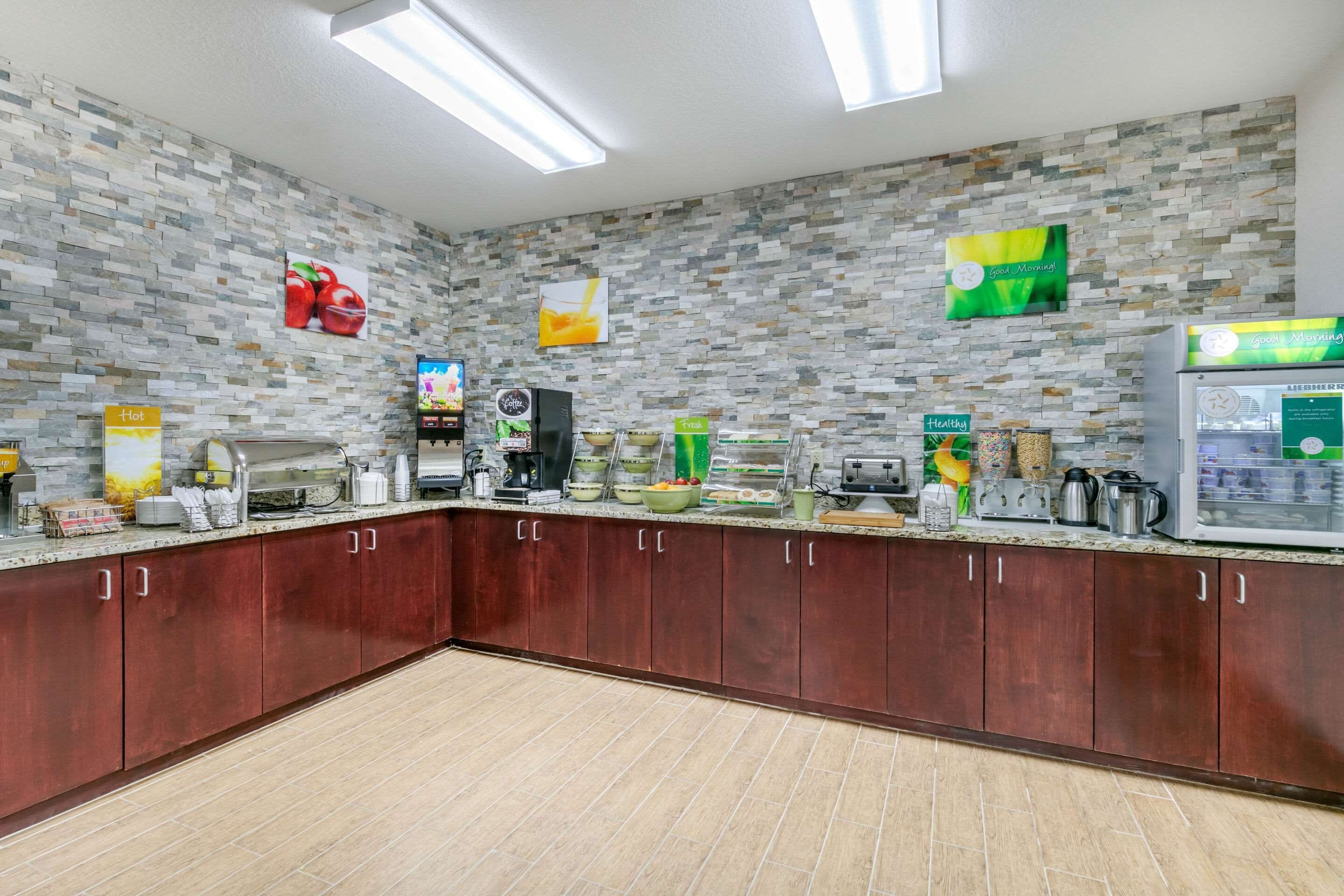 Keittiössä on kivestä tehty välitila, puiset kaapit ja erilaisia kodinkoneita.