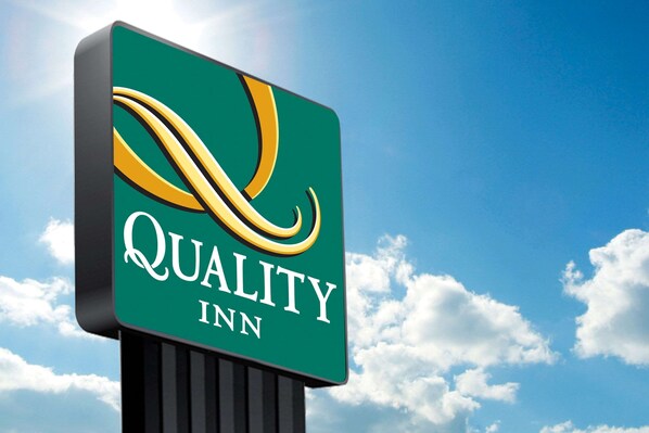 A sign for Quality Inn with a green background and a stylized yellow and black logo. - Quality Inn Monteagle (Monteagle)