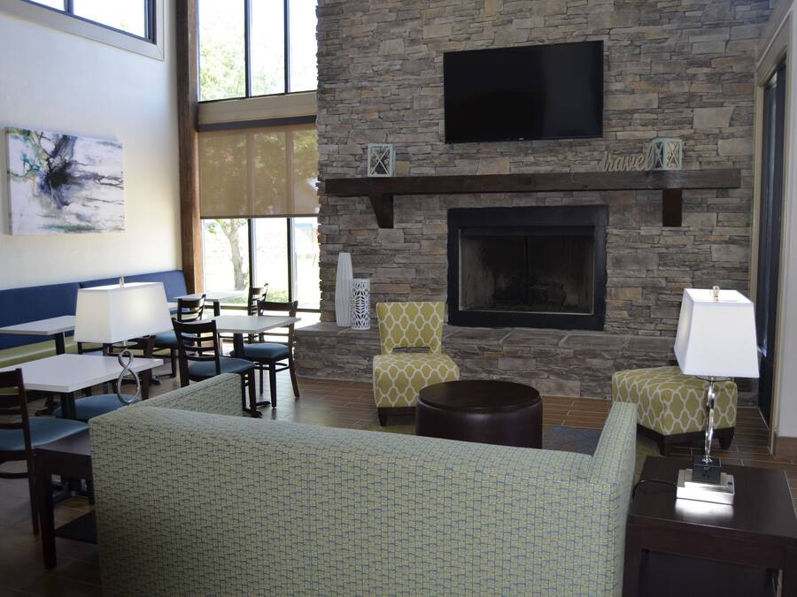A lounge area with a stone fireplace, seating, and artwork.