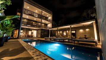 Alberca al aire libre, sombrillas en la alberca y camastros