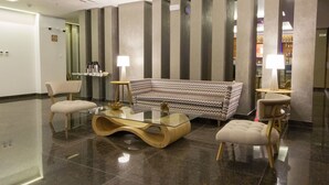 A modern lobby with a glass coffee table, a patterned sofa, and two chairs. - Tierra Viva Trujillo (Trujillo)