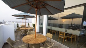 A rooftop terrace with wicker furniture, glass walls, and umbrellas. - Tierra Viva Trujillo (Trujillo)