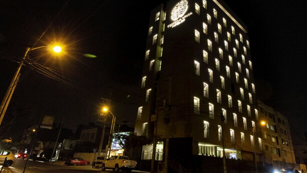 A multi-story hotel with illuminated windows and a prominent logo on the facade. - Tierra Viva Trujillo (Trujillo)