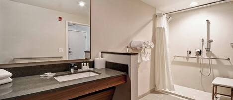 A modern bathroom with a sink, mirror, and shower.