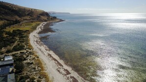 A coastal landscape with a sandy beach, clear water, and a hilly backdrop. - 20 Lady Bay Road Normanville (Normanville)