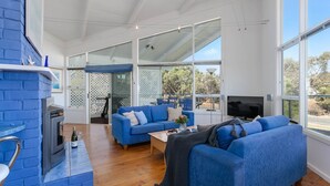 Una sala de estar moderna con un sofá azul, una mesa de centro y una chimenea.