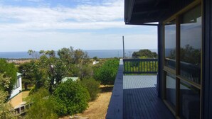 A balcony with a view of the sea and surrounding greenery. - Tree Top - 4 Robert Norman Street (NORMANVILLE)