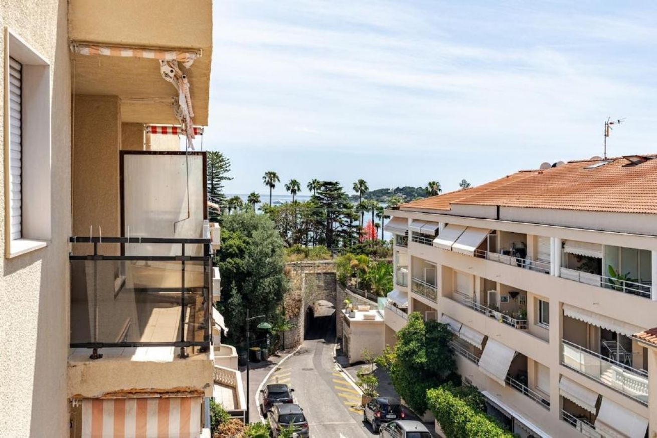 Ein Wohngebäude mit Balkonen, einer Straße und Blick auf das Meer.