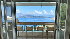 Ein Balkon mit Korbstühlen und Blick aufs Meer.