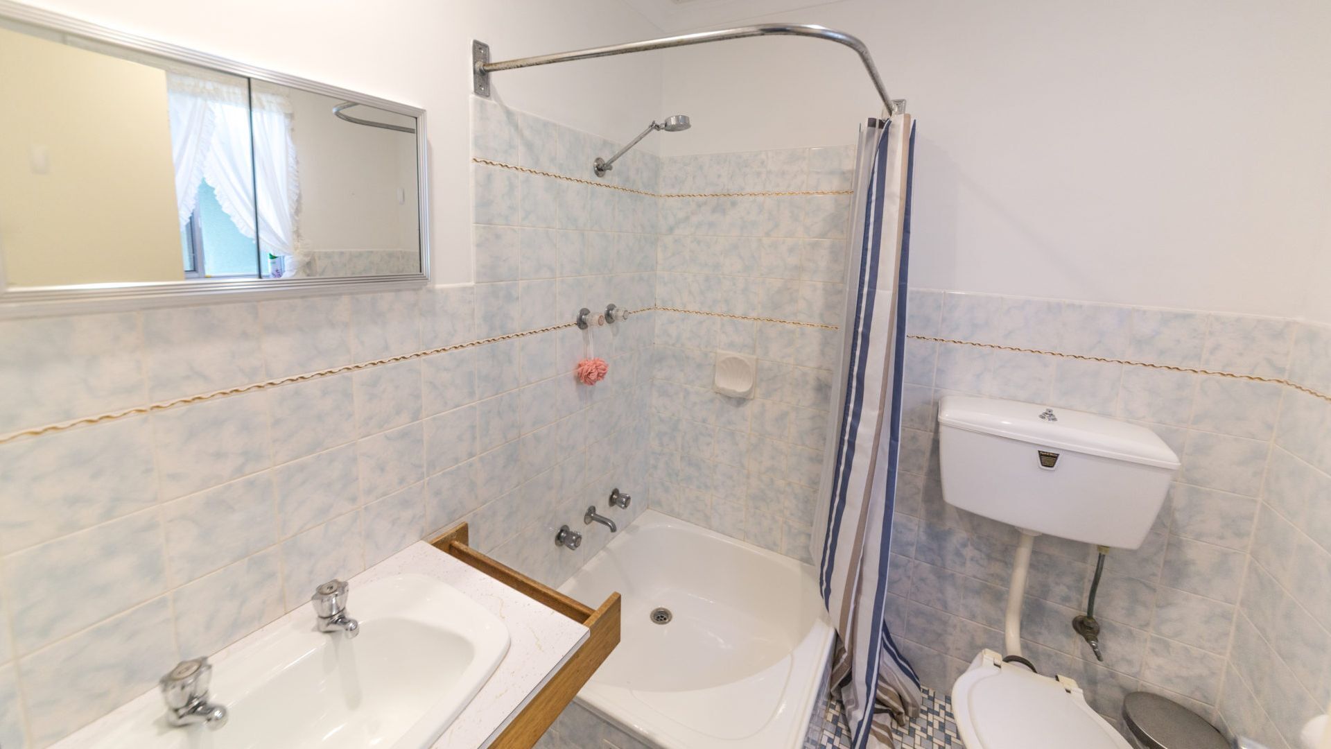 A bathroom with a bathtub, two sinks, a toilet, and a shower area.