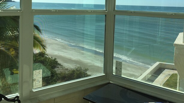 A room with a large window overlooking a beach. - First Lido - New pool deck, and landscaping, 
New elevator, Freshly painted (Sarasota)